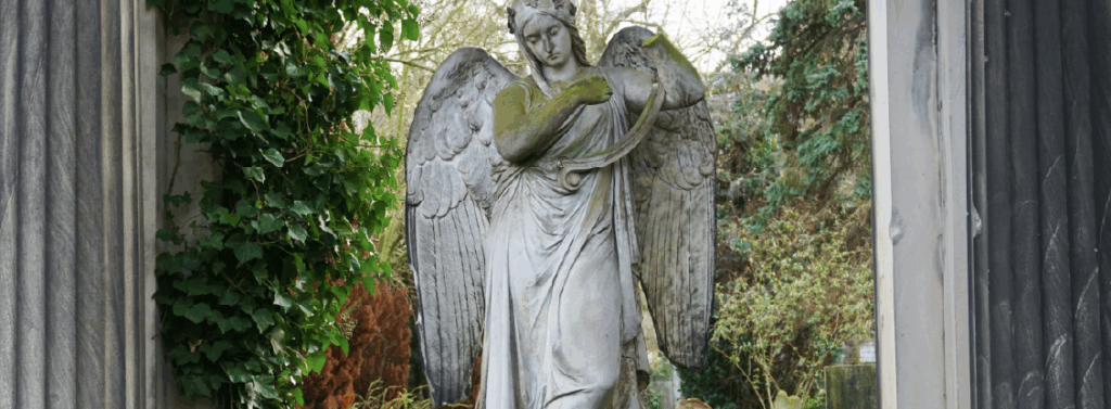 woman in dress statue near black metal fence